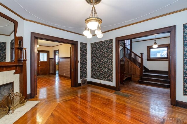 1628 E 5th St, Dayton, OH 45403 - unfurnished dining area with wood finished floors, baseboards, plenty of natural light, and crown molding