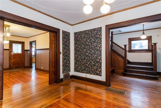 1628 E 5th St, Dayton, OH 45403 - empty room featuring wood finished floors, ornamental molding, stairs, baseboards, and wainscoting