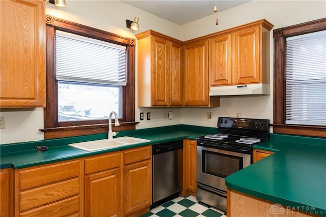 1628 E 5th St, Dayton, OH 45403 - kitchen with stainless steel appliances, a sink, under cabinet range hood, light flooring, and dark countertops