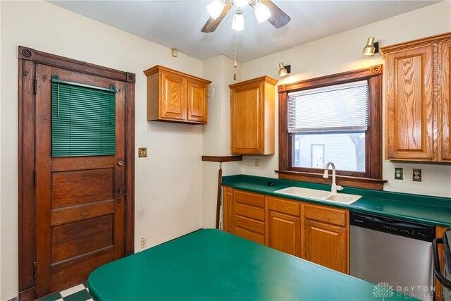 1628 E 5th St, Dayton, OH 45403 - kitchen featuring dishwasher, a sink, ceiling fan, dark countertops, and brown cabinetry
