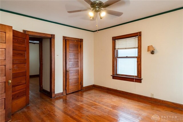 1628 E 5th St, Dayton, OH 45403 - unfurnished bedroom featuring wood finished floors, baseboards, and ceiling fan