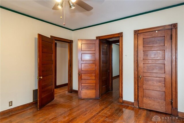 1628 E 5th St, Dayton, OH 45403 - unfurnished bedroom featuring baseboards, wood finished floors, and ceiling fan