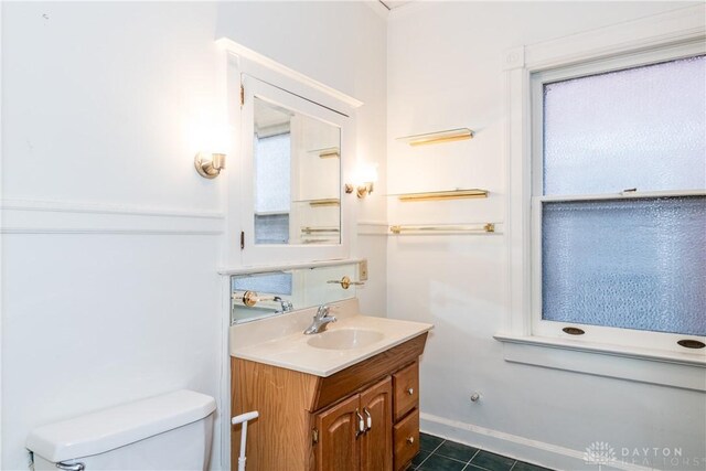 1628 E 5th St, Dayton, OH 45403 - half bath featuring vanity, toilet, tile patterned floors, and baseboards