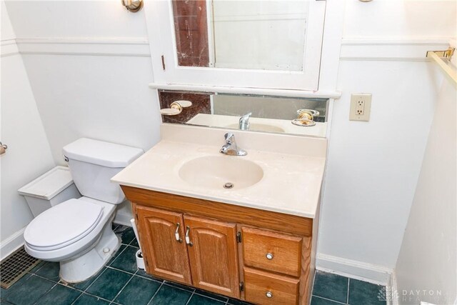 1628 E 5th St, Dayton, OH 45403 - half bath with vanity, toilet, tile patterned floors, and baseboards