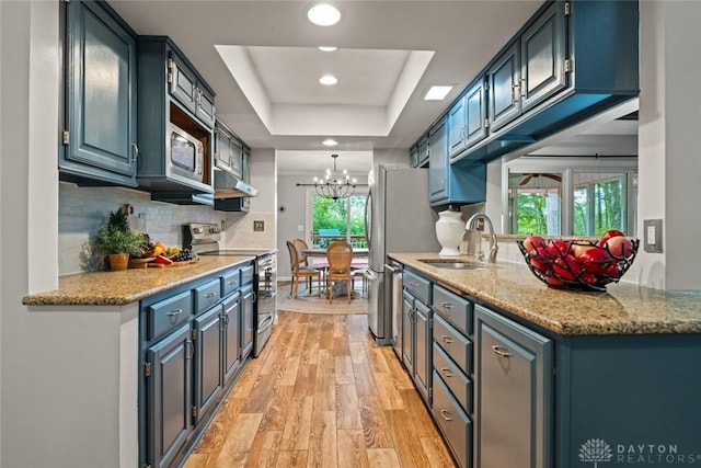286 Honey Jane Dr, Beavercreek, OH 45434 - kitchen with stainless steel appliances, a sink, a raised ceiling, under cabinet range hood, and light wood-style floors