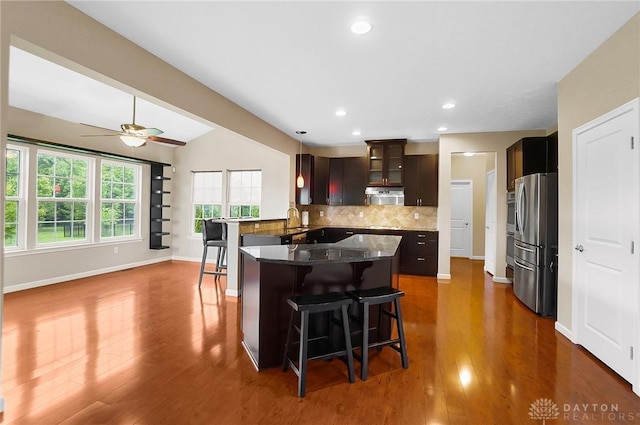 9752 Crooked Creek Dr, Centerville, OH 45458 - kitchen featuring appliances with stainless steel finishes, a breakfast bar area, decorative backsplash, baseboards, and dark wood-type flooring