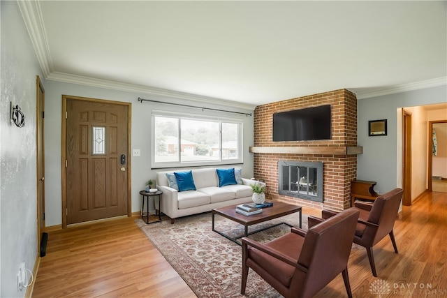 692 Sueden Dr, Beavercreek, OH 45430 - living room featuring light wood finished floors, crown molding, a brick fireplace, and baseboards
