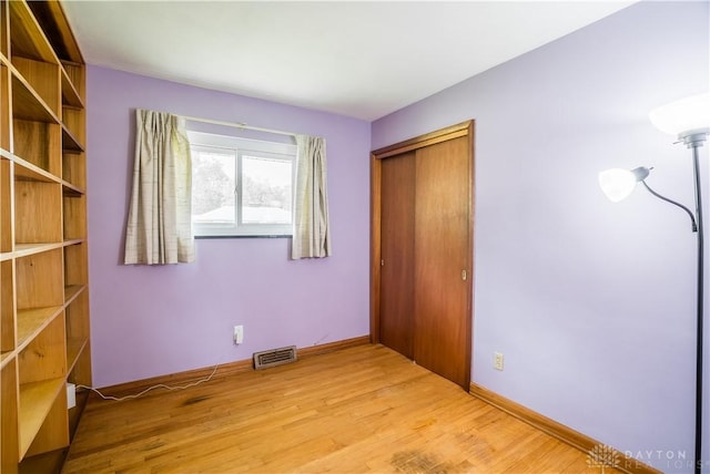692 Sueden Dr, Beavercreek, OH 45430 - unfurnished bedroom with light wood-style flooring, a closet, and baseboards