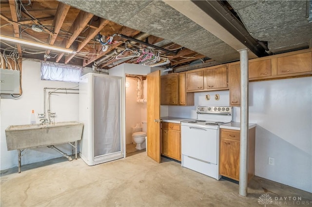 692 Sueden Dr, Beavercreek, OH 45430 - kitchen with white electric range, electric panel, unfinished concrete flooring, light countertops, and brown cabinets