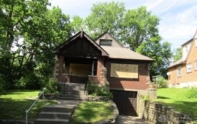 5038 W High St, Cincinnati, OH 45238 - view of front of property featuring brick siding, a front lawn, an attached garage, and stairway