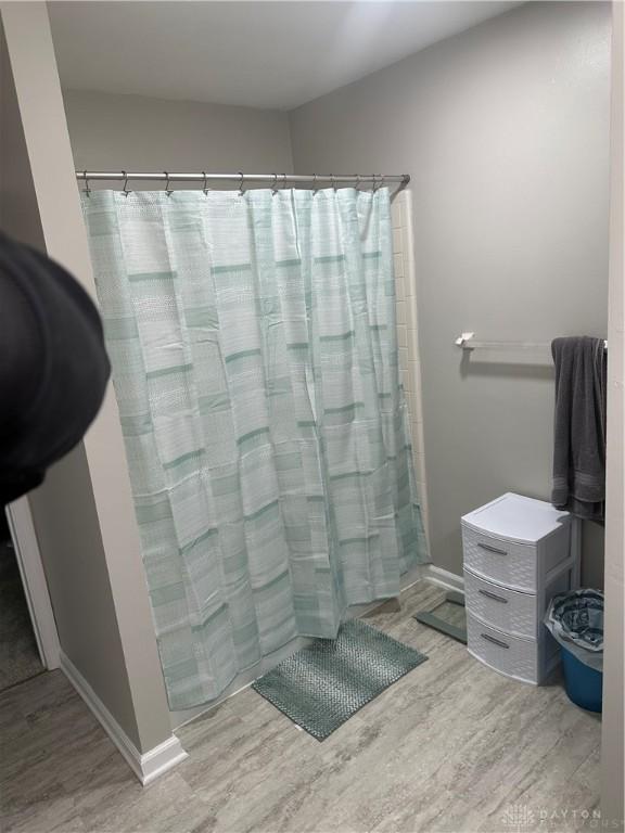 2419 Meadow Green Dr, Beavercreek, OH 45431 - bathroom featuring wood finished floors, a shower with curtain, and baseboards