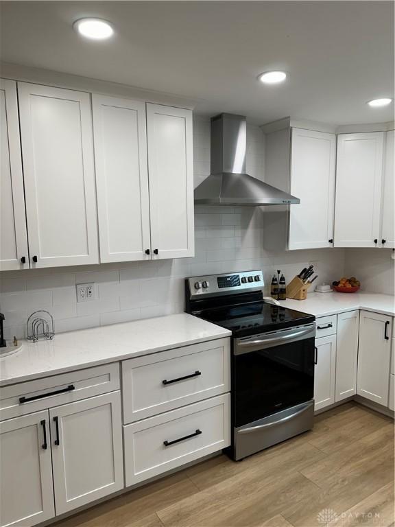 2419 Meadow Green Dr, Beavercreek, OH 45431 - kitchen with wall chimney exhaust hood, stainless steel electric range oven, white cabinets, light countertops, and recessed lighting