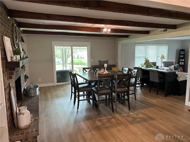 2419 Meadow Green Dr, Beavercreek, OH 45431 - dining space featuring wood finished floors, beamed ceiling, a brick fireplace, and baseboards