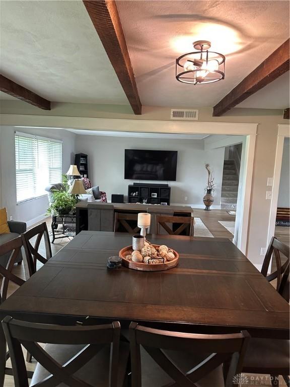 2419 Meadow Green Dr, Beavercreek, OH 45431 - dining room featuring beamed ceiling, baseboards, and stairway