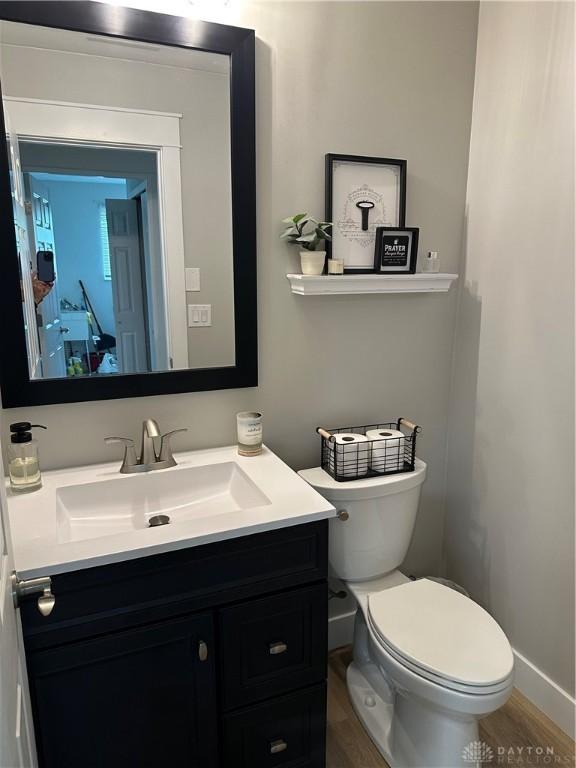 2419 Meadow Green Dr, Beavercreek, OH 45431 - bathroom with vanity, toilet, wood finished floors, and baseboards