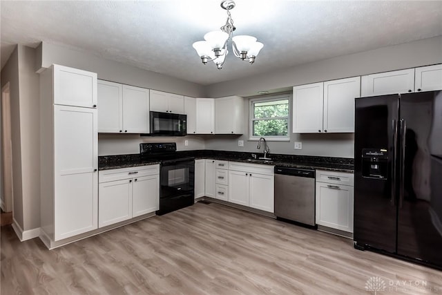 5920 Verdi Dr, West Carrollton, OH 45449 - kitchen with black appliances, a sink, a chandelier, white cabinetry, and light wood finished floors