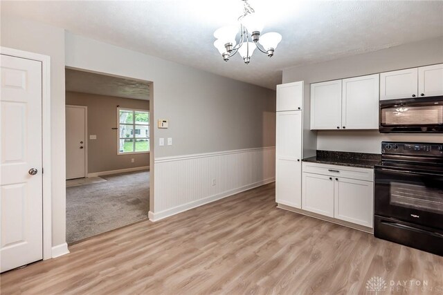 5920 Verdi Dr, West Carrollton, OH 45449 - kitchen featuring black / electric stove, a chandelier, light wood finished floors, white cabinetry, and a wainscoted wall