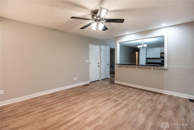 5920 Verdi Dr, West Carrollton, OH 45449 - unfurnished living room featuring baseboards, a ceiling fan, light wood-style flooring, a chandelier, and recessed lighting
