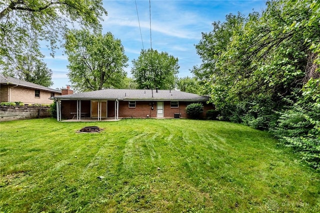 5920 Verdi Dr, West Carrollton, OH 45449 - back of house with a fire pit, brick siding, and a patio area
