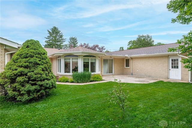 2301 Glenheath Dr, Kettering, OH 45440 - back of property with a patio area, a lawn, and brick siding