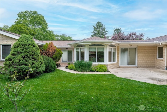 2301 Glenheath Dr, Kettering, OH 45440 - back of house with a lawn, brick siding, and a patio area