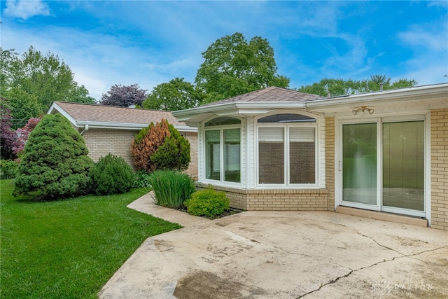 2301 Glenheath Dr, Kettering, OH 45440 - view of front of home featuring brick siding, a patio area, a front yard, and a shingled roof