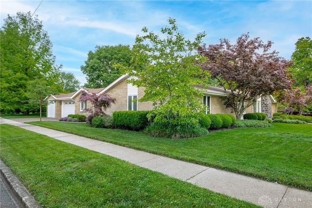 2301 Glenheath Dr, Kettering, OH 45440 - view of property hidden behind natural elements featuring a garage, a front yard, brick siding, and driveway