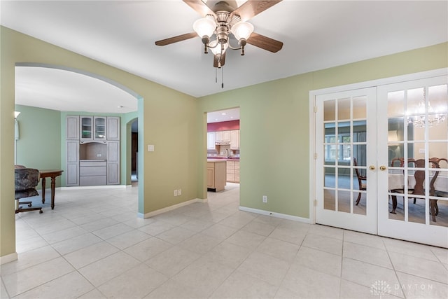 2301 Glenheath Dr, Kettering, OH 45440 - spare room with arched walkways, a ceiling fan, light tile patterned floors, french doors, and baseboards