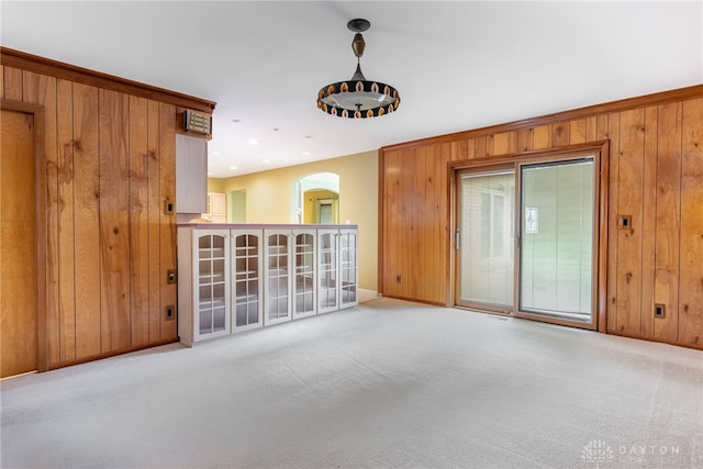 2301 Glenheath Dr, Kettering, OH 45440 - spare room featuring arched walkways, wood walls, baseboards, and carpet flooring
