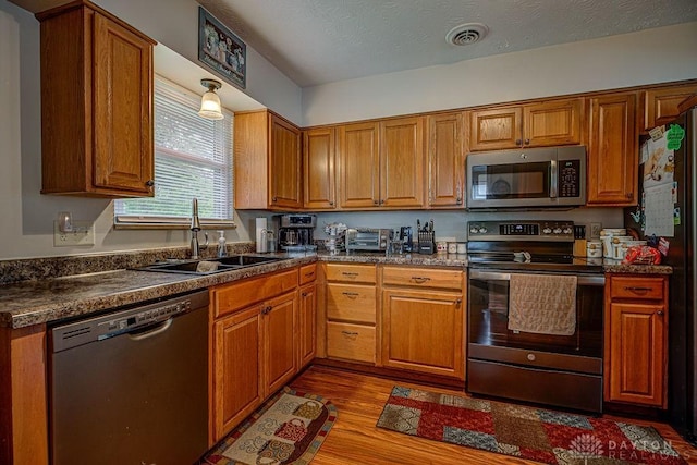 286 Chamberlin Dr, Hamilton, OH 45013 - kitchen featuring appliances with stainless steel finishes, a sink, wood finished floors, and dark countertops
