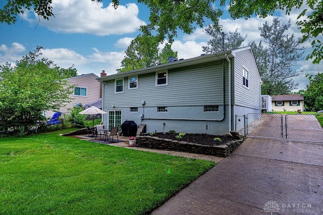 286 Chamberlin Dr, Hamilton, OH 45013 - back of house featuring a gate, a lawn, a patio, and driveway