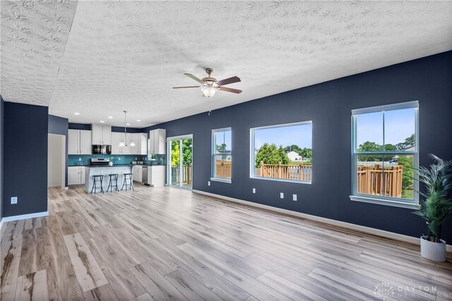 109 Waterford Blvd, Fairborn, OH 45324 - unfurnished living room with light wood-style floors, a ceiling fan, and a textured ceiling