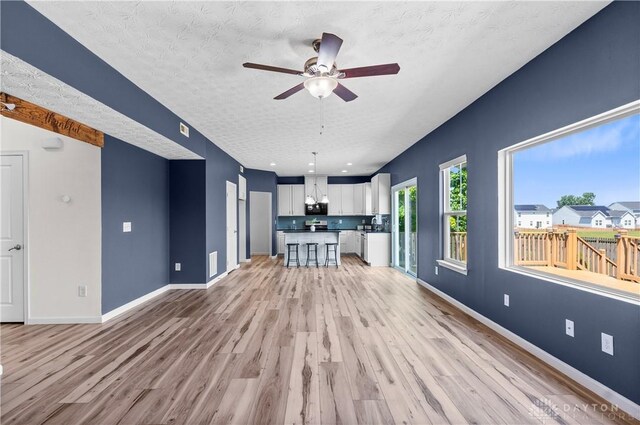 109 Waterford Blvd, Fairborn, OH 45324 - unfurnished living room with light wood-type flooring, a textured ceiling, and ceiling fan