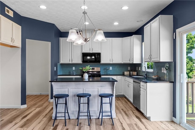109 Waterford Blvd, Fairborn, OH 45324 - kitchen with stainless steel appliances, dark countertops, light wood-style flooring, tasteful backsplash, and recessed lighting