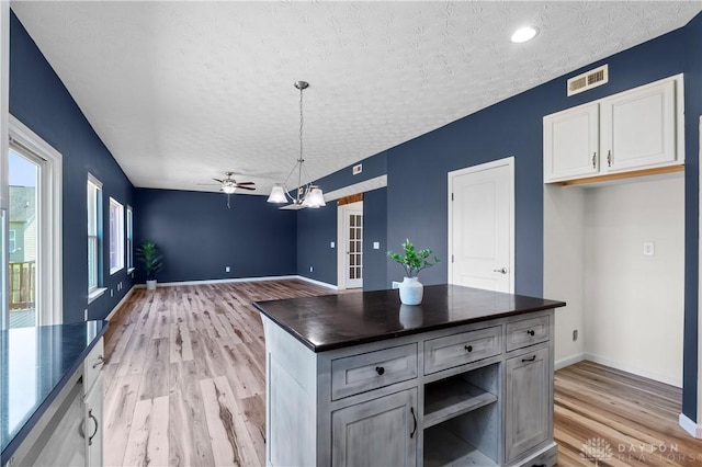 109 Waterford Blvd, Fairborn, OH 45324 - kitchen featuring dark countertops, a textured ceiling, light wood-style flooring, a chandelier, and a ceiling fan