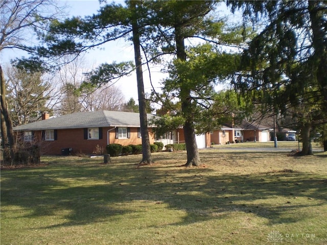 1086 Grange Hall Rd, Beavercreek, OH 45430 - ranch-style home with a chimney, a front yard, and an attached garage