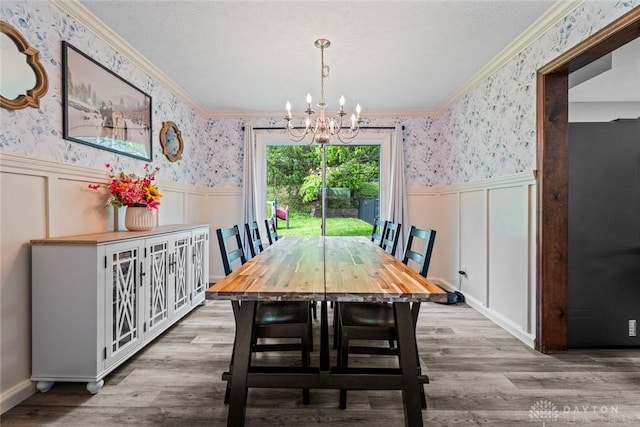 360 Merrick Dr, Beavercreek, OH 45434 - dining room featuring wallpapered walls, crown molding, wainscoting, a chandelier, and wood finished floors