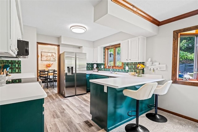 360 Merrick Dr, Beavercreek, OH 45434 - kitchen featuring stainless steel fridge with ice dispenser, a peninsula, decorative backsplash, white cabinets, and crown molding