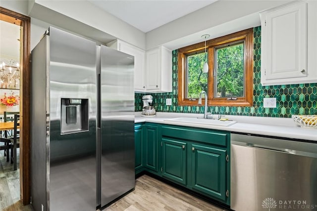 360 Merrick Dr, Beavercreek, OH 45434 - kitchen featuring appliances with stainless steel finishes, a sink, white cabinets, light wood-style flooring, and light countertops