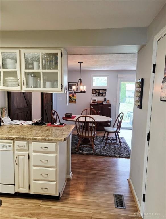 1008 Terracewood Dr, Englewood, OH 45322 - kitchen featuring wood finished floors, white dishwasher, light countertops, and glass insert cabinets