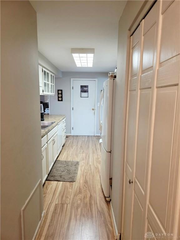 1008 Terracewood Dr, Englewood, OH 45322 - washroom with light wood-type flooring, washer and clothes dryer, cabinet space, and baseboards