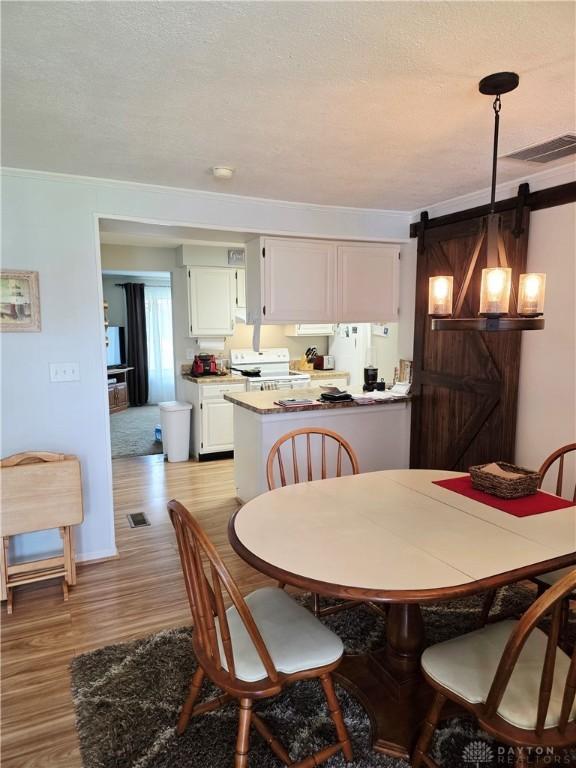 1008 Terracewood Dr, Englewood, OH 45322 - dining space with a barn door and wood finished floors
