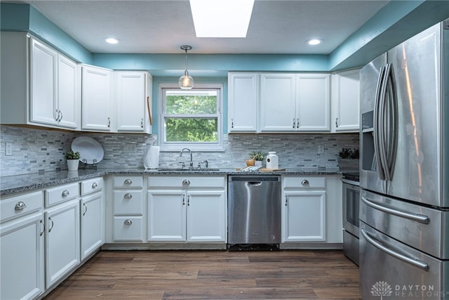 1172 Bay Ln, Beavercreek, OH 45430 - kitchen with stainless steel appliances, a sink, a skylight, white cabinetry, and recessed lighting