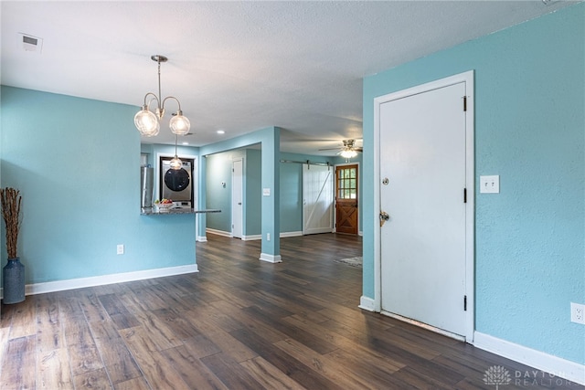 1172 Bay Ln, Beavercreek, OH 45430 - unfurnished living room with a barn door, dark wood finished floors, baseboards, and a ceiling fan