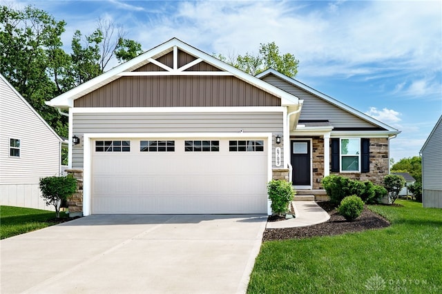 6709 Crystal Harbour Dr, Middletown, OH 45042 - craftsman-style house with stone siding, driveway, a garage, a front lawn, and board and batten siding