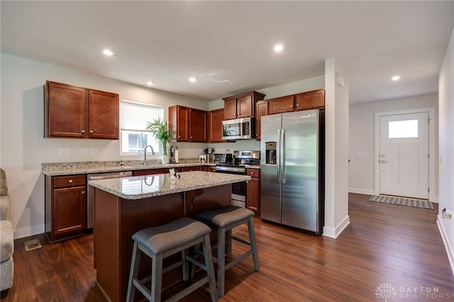 6709 Crystal Harbour Dr, Middletown, OH 45042 - kitchen with stainless steel appliances, a sink, a center island, dark wood finished floors, and light stone countertops
