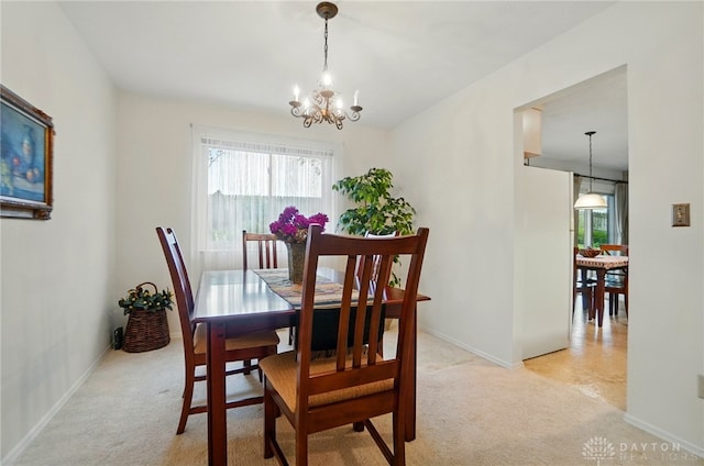 348 Cambridge Dr, Fairborn, OH 45324 - dining room with light carpet, a chandelier, and baseboards