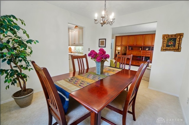 348 Cambridge Dr, Fairborn, OH 45324 - dining room featuring light colored carpet, a chandelier, and baseboards