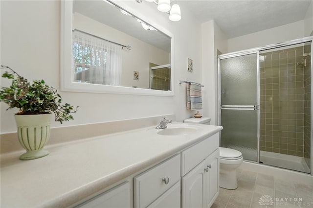 348 Cambridge Dr, Fairborn, OH 45324 - bathroom featuring toilet, vanity, tile patterned floors, and a stall shower