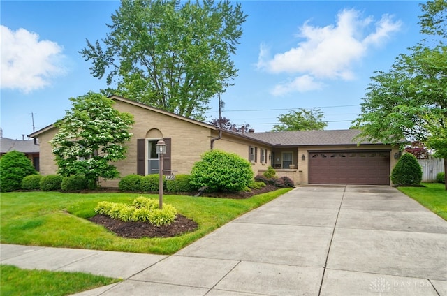 348 Cambridge Dr, Fairborn, OH 45324 - ranch-style house with an attached garage, a front lawn, driveway, and brick siding